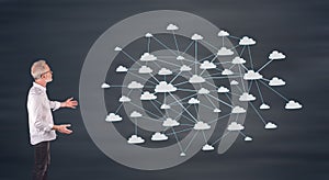 A cloud network concept explained by a businessman on a wall screen