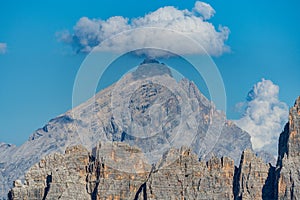 Cloud over single piramid like mountain peak in sunny day