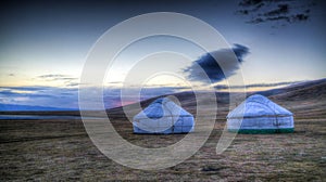 Cloud over the yurts at the shore of Song Kol Lake at the dawn, Kyrgyzstan