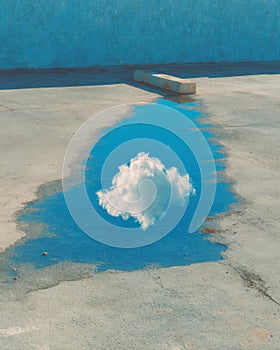 Cloud Reflection in Blue Puddle on Concrete