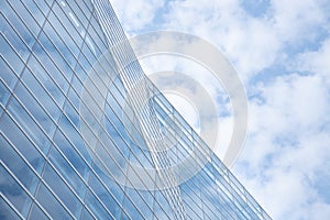 Cloud and sky reflected in the blue glass windows of building