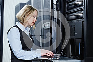 Cloud storage service. female engineer works with laptop in data center