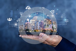 Cloud technology in smart city concept with human hand carries digital tablet with megapolis city skyscrapers