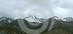 Clouds above mountains covered with snow