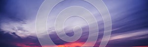 Clouds against a background of purple cloudy dramatic sky at sunset in evening. Panorama of the sky