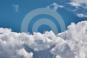 Clouds against the blue sky are brightly lit by the sun. Abstract background. Copy space