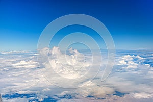 Clouds against blue sky view through an airplane window for a background