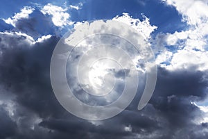 Clouds in black grey white colors in blue sky leaving region after a rainy weather period on a spring summer day and bright sun