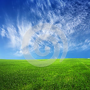 Clouds on blue sky and green field