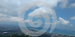 Clouds on blue sky with ocean, city and mountains, background wallpaper, landscape