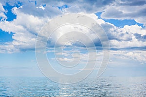 Clouds in blue sky over calm water of Azov Sea photo