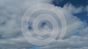 Clouds in blue sky slowly move and change shape. Changing stratocumulus cloudscape. Timelapse.