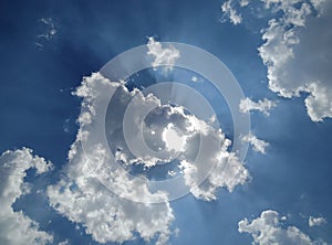 Clouds in blue sky with sun rays