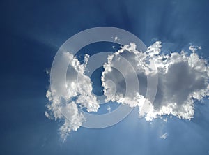 Clouds in blue sky with sun rays