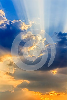 Clouds and a blue sky with a sunbeam shining through.