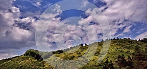 Clouds casting shadows on the slopes of the mountains during sunset. The play of light and shadow.
