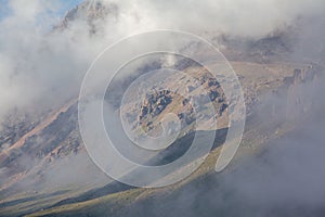 Clouds coverig rocks in mountains of Tien Shan