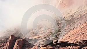 Clouds drift gently across the steep red cliffs on Zion Nat. Park