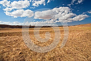 Clouds floating over dry grass land