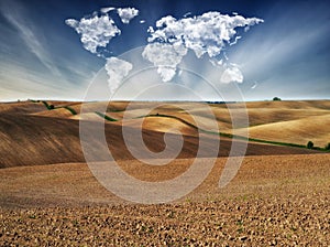 Clouds in the form of a map of the world over the field. Travel and landscape concept