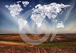Clouds in the form of a map of the world over the field. Travel and landscape concept
