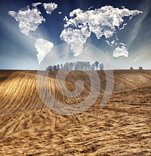 Clouds in the form of a map of the world over the field. Travel and landscape concept