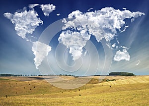 Clouds in the form of a map of the world over the field. Travel and landscape concept