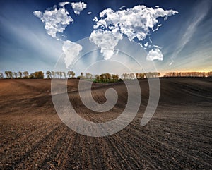 Clouds in the form of a map of the world over the field. Travel and landscape concept