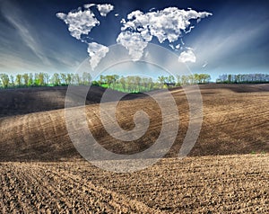 Clouds in the form of a map of the world over the field. Travel and landscape concept