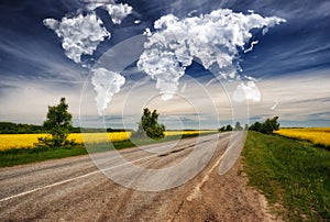 Clouds in the form of a map of the world over a hilly field. Travel and landscape concept