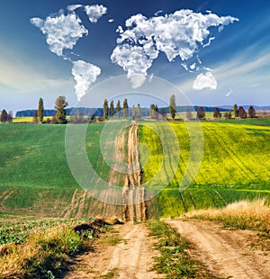 Clouds in the form of a map of the world over a hilly field. Travel and landscape concept