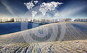 Clouds in the form of a world map over a winter field. travel and landscape concept