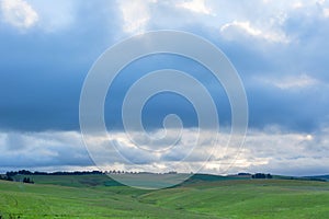 Clouds gathering over green pastures