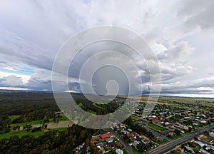 clouds are gathering over a suburban area in the middle of an aerial photo