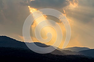 Clouds and golden sunbeam over mountain