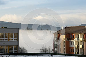 Clouds inversion on the meadow and around the town.