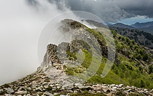 Clouds meet the top of a mountain ridge on GR20 in Corsica photo