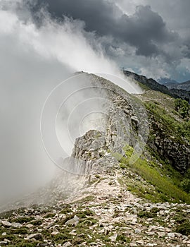 Clouds meet the top of a mountain ridge on GR20 in Corsica photo