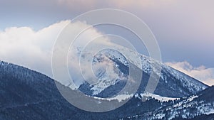 Clouds moving over the mountain during twiligh in winter landscape. Timelapse