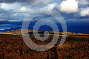 Clouds over the lake in the mountainous part of the tundra in autumn