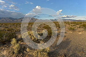 Clouds over mountain range and row of houses in Mojave Desert landscape town of Pahrump, Nevada, USA