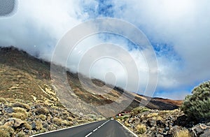 Clouds over the mountains near the Teide volcano on the island of Tenerife, motion, blurry, view from the car, track in the clouds