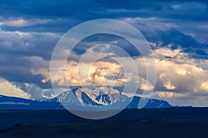 Clouds passing over mountain pinnacle in sunset light