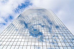 Clouds reflect off mirrored glass skyscraper