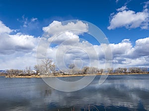 Clouds reflect in in quiet blue lake