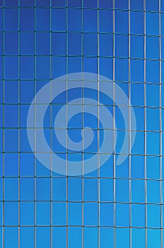 Clouds are reflected in windows of modern office building. Blue glass facade of the Hyatt Hotel