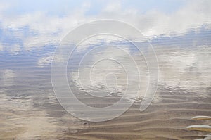 Clouds reflection on a water pond in Santa Ana beach, near Juan Lacaze, Colonia, Uruguay photo