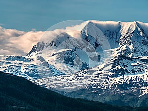 Clouds roll over mountain tops in dramatic landscape