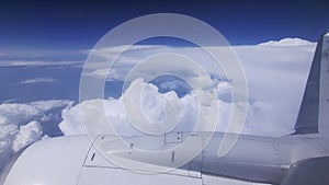 Clouds seen through the window of jet airplane. Airplane flies above the weather