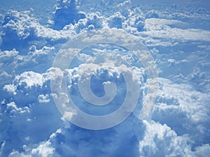 Clouds and sky from airplane window view. White cumulus clouds formation in blue sky. Beauty white cloudy on blue sky with soft